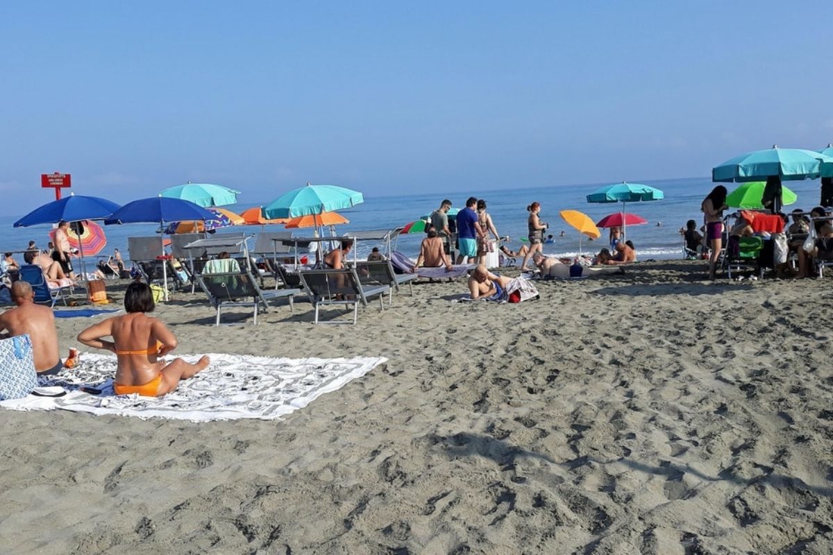 Vista di una spiaggia affollata a Civitanova Marche, con ombrelloni e persone che si divertono