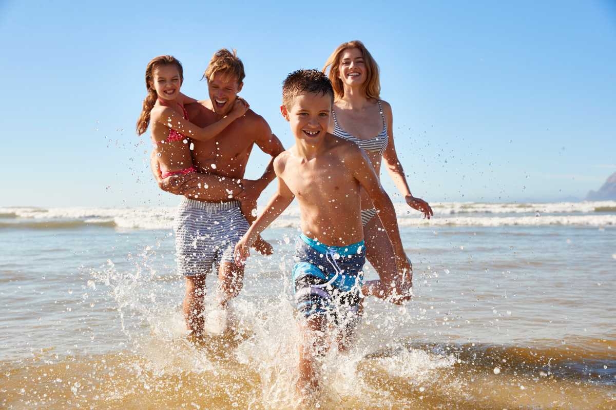 Spiaggia di Pesaro con vista sul mare, persone che si rilassano sotto gli ombrelloni